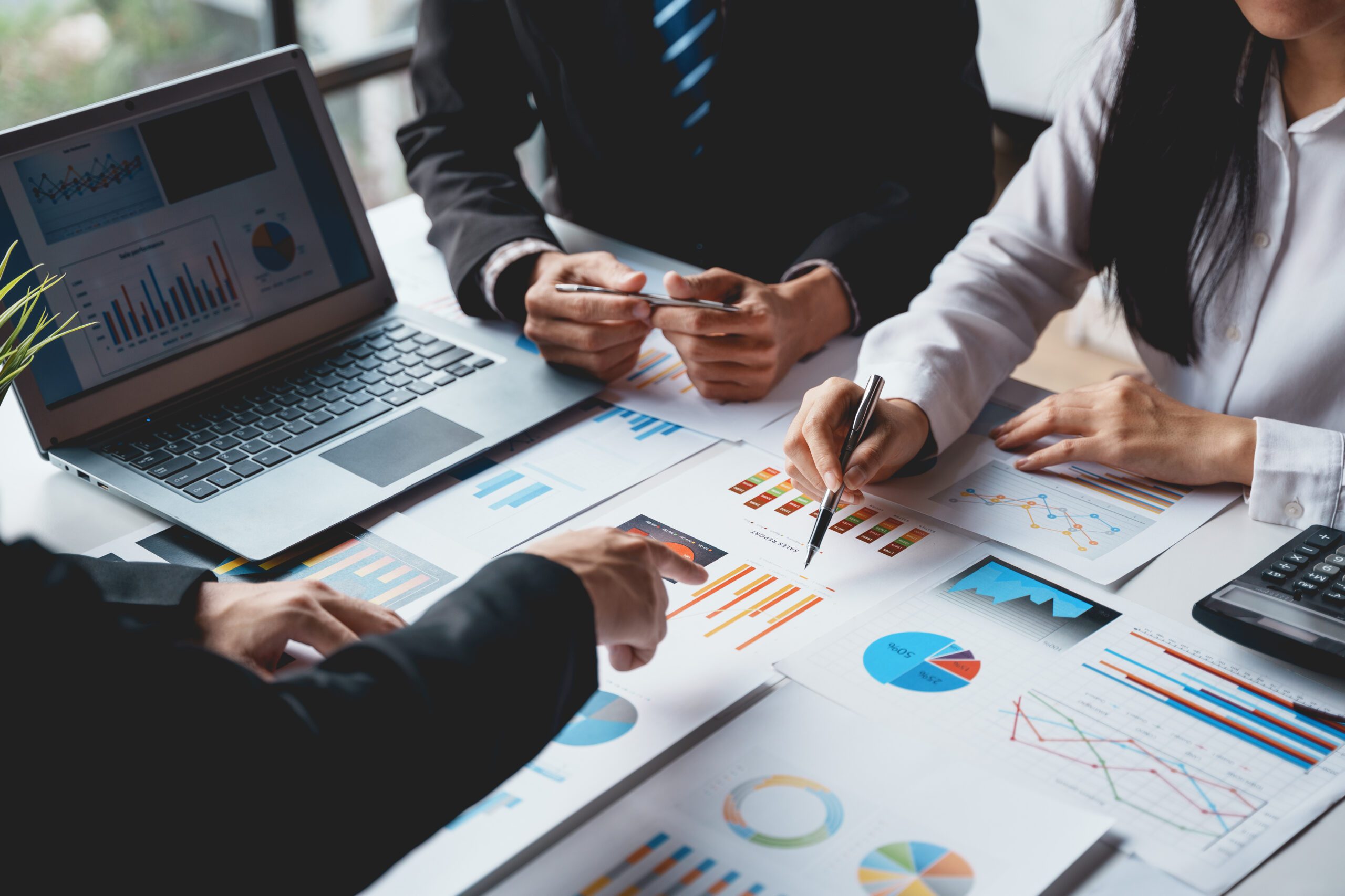 Group of business people meeting to plan, analyze, graph and chart corporate growth to plan new business expansions in the future.